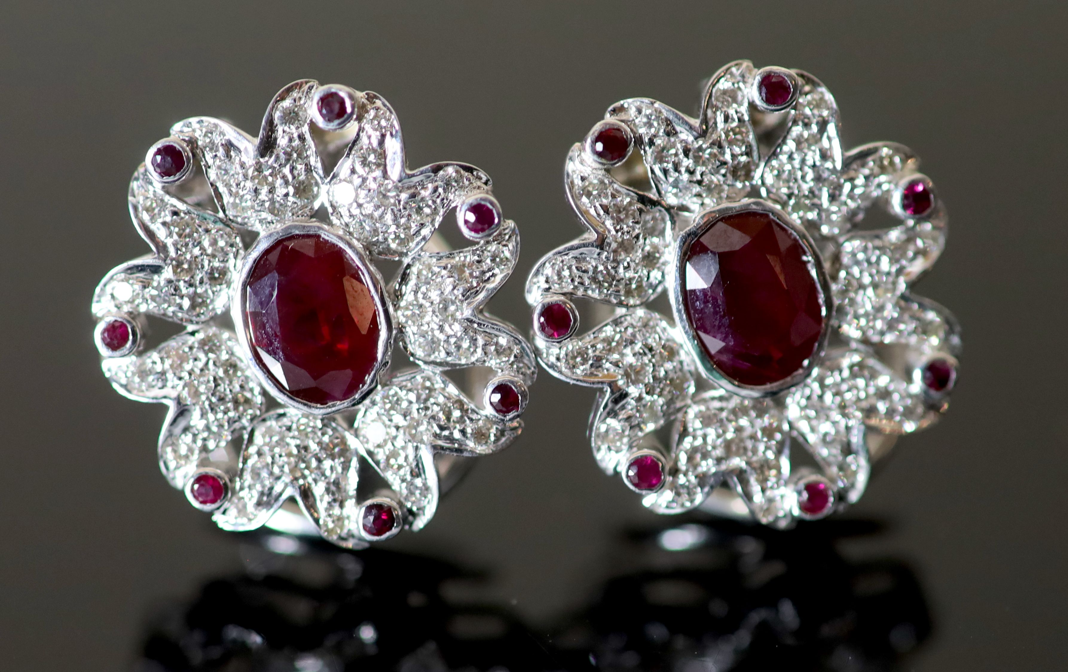 A pair of modern continental 18k white gold, ruby and diamond set oval cluster flower head earrings,